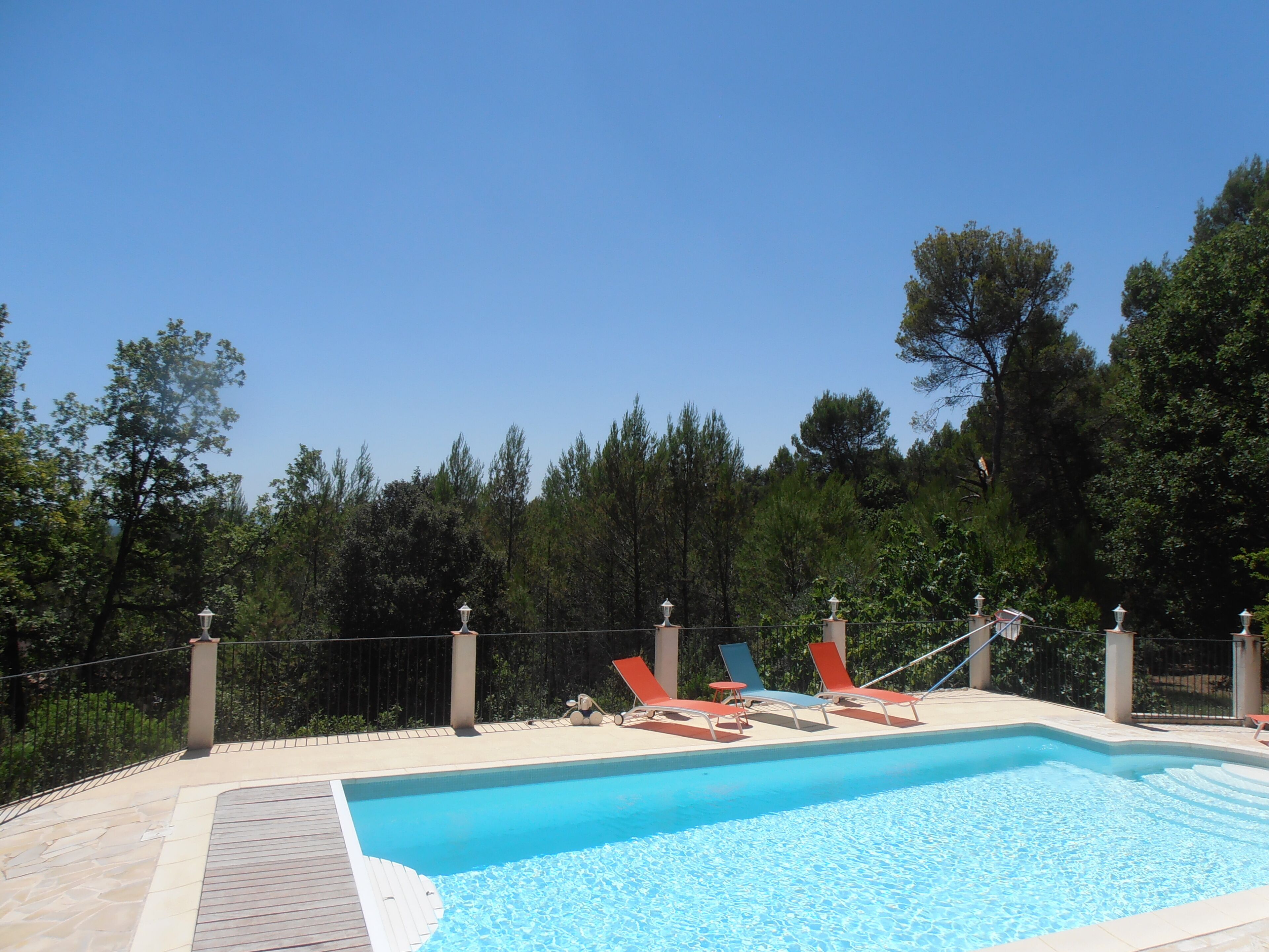 A swimming pool with lounge chairs and a lamp post.