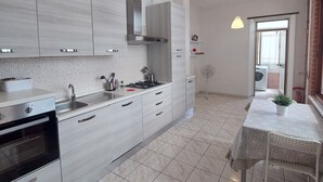 A modern kitchen with a central island, stainless steel appliances, and pendant lighting. - Domus Dejanas 180sqm apartment in the center of Quartu Sant'Elena (Quartu Sant'Elena)