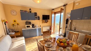 Una cocina con una mesa de comedor dispuesta para el desayuno, un microondas y vistas al exterior.
