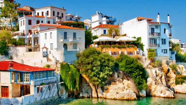 A coastal town with buildings on a rocky cliff, overlooking the sea.