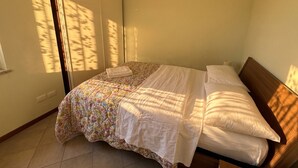 A bedroom with a bed, a wardrobe, and a window casting shadows. - La Quiete 23 Holideal Apartment Lake View (Tremosine)