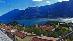 A residential area with a swimming pool, terraced houses, and a view of a lake and mountains. - La Quiete 23 Holideal Apartment Lake View (Tremosine)