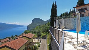 A pool area with lounge chairs and umbrellas, overlooking a mountainous landscape and a body of water. - La Quiete 23 Holideal Apartment Lake View (Tremosine)