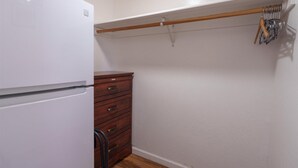 Eine kompakte Küche mit einem weißen Kühlschrank, einer Holzschrankfront und einem Holzbalken über den Schränken.