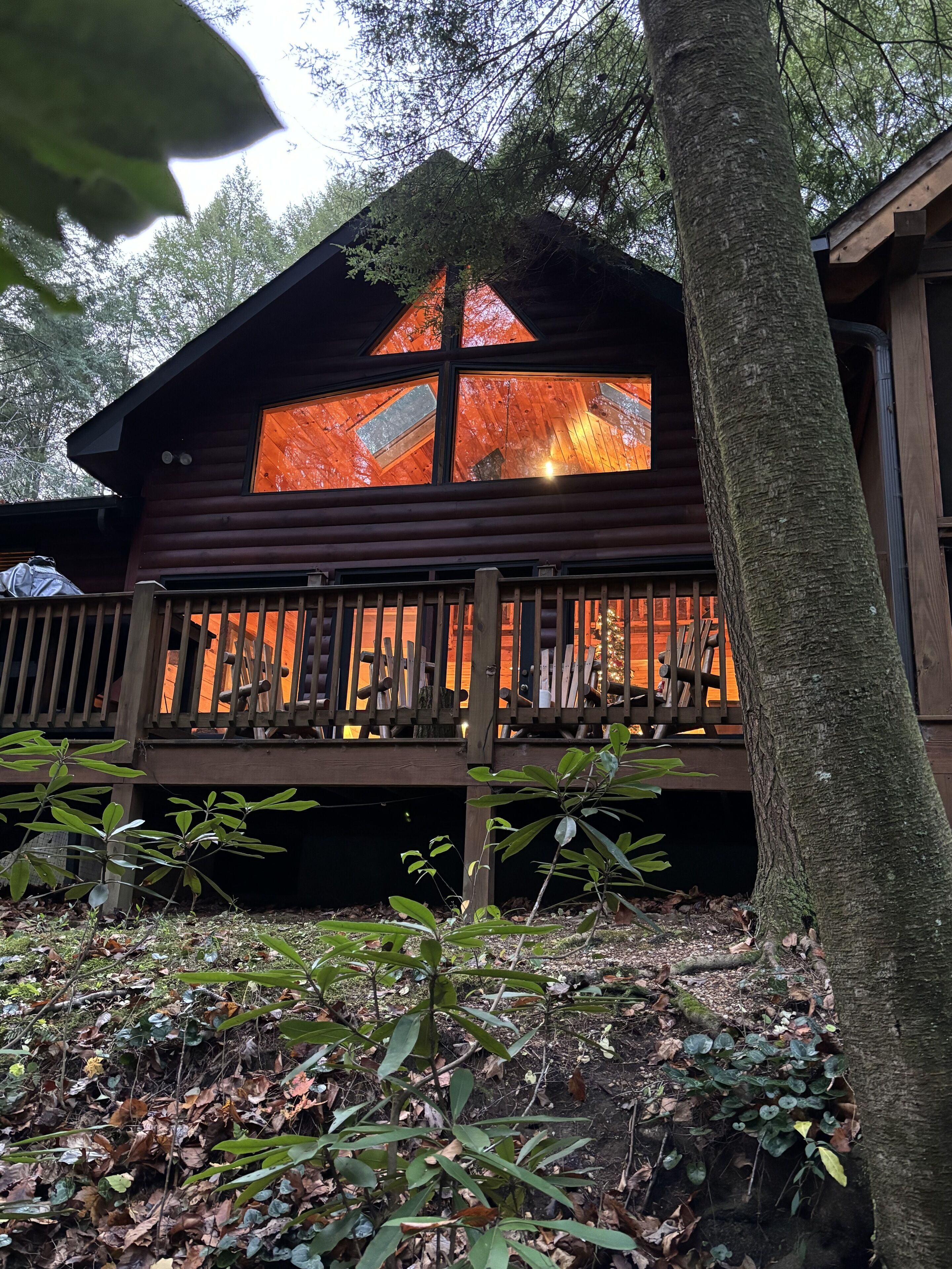 A cabin with a wooden deck and large windows.