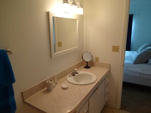 Une salle de bain équipée d’un lavabo, d’un miroir et d’articles de toilette.