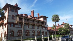 A large, historic building with multiple stories, arched windows, and a balcony. - 2/2 Condo, Ground Floor, 2 Parking Spaces, Pool (Saint Augustine Beach)