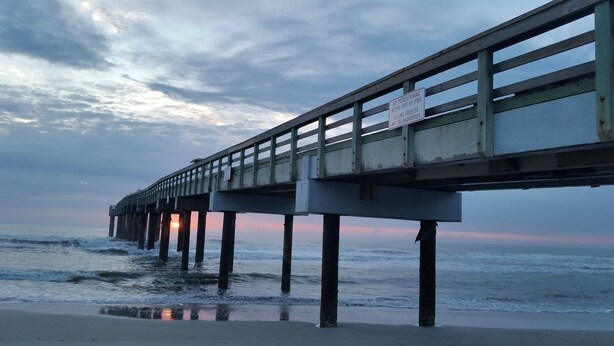 A pier extending over the water with a sunset in the background. - 2/2 Condo, Ground Floor, 2 Parking Spaces, Pool (Saint Augustine Beach)
