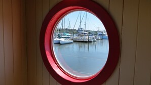 A view through a circular window of a marina with several boats docked. - 2/2 Condo, Ground Floor, 2 Parking Spaces, Pool (Saint Augustine Beach)