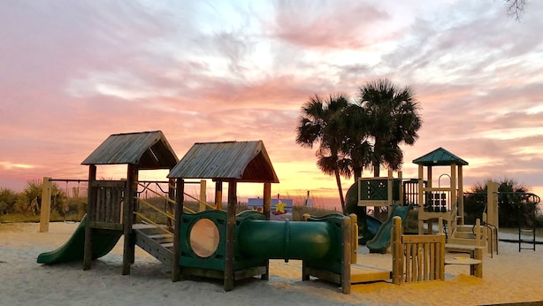 A beach playground with slides and climbing structures.