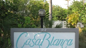 A sign for Casa Blanca with a number 312 above it, surrounded by greenery.
