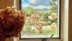 A window with a view of a garden and a chandelier. - Stunning Mountain view from in-town location. Walk to town!! (Highlands)