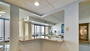 Un interior moderno con una isla de cocina, ventanas amplias y un comedor a la vista.