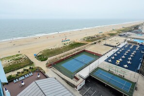 Una playa con cancha de tenis y zona de piscina.