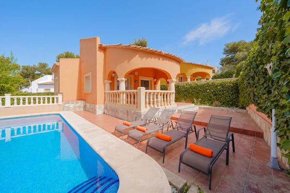 A poolside area with lounge chairs and a swimming pool.