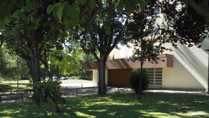 Un edificio dal design moderno, circondato da un'area verde curata e alberi.