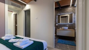 A hotel room with a bed, a bathroom with a marble wall, and a sink. - Rivadige Suite 3 - Verona Journeys (Verona)