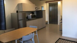 A modern kitchen with a dining area, a refrigerator, a microwave, and a coffee machine. - Rivadige Suite 3 - Verona Journeys (Verona)