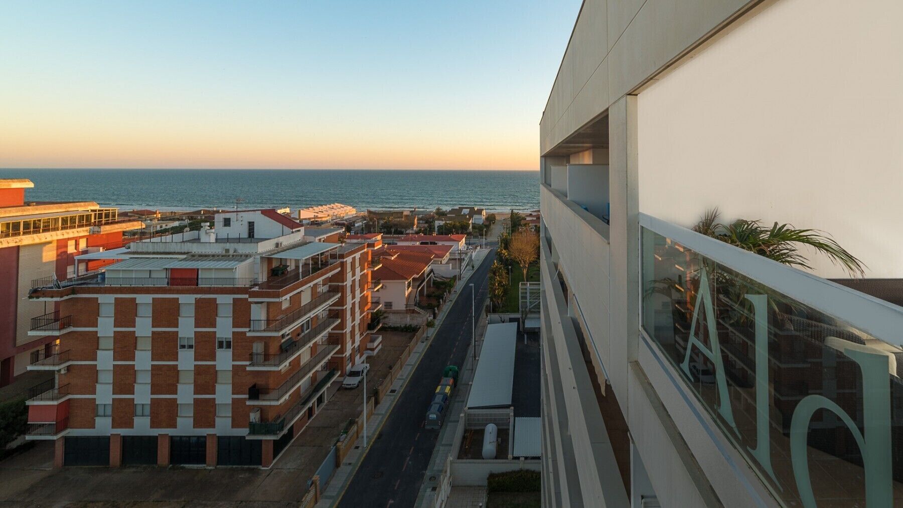 Un immeuble de grande hauteur offrant une vue sur la mer et donnant sur des immeubles résidentiels voisins.