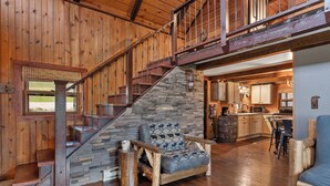 A wooden interior with a stone staircase, a dining area, and a kitchen. - Circle J Lodge, Relaxing pet friendly cabin at Terry Peak with new hot tub! (Lead)