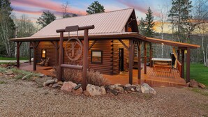 A log cabin with a porch, a hot tub, and a wooden deck. - Circle J Lodge, Relaxing pet friendly cabin at Terry Peak with new hot tub! (Lead)