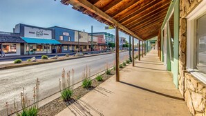 A street view with a covered walkway, storefronts, and a road. - Downtown Gilbert Getaway - Sleeps 8 (Gilbert)