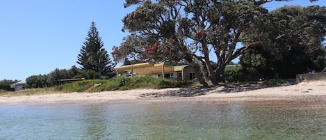 Une propriété située en bord de mer, comprenant une maison, une eau cristalline et une végétation luxuriante.