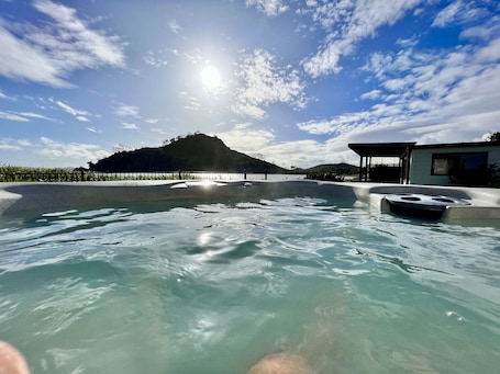 Outdoor spa tub. Beachside Cabin with view of Mount Pataua and Surf bar