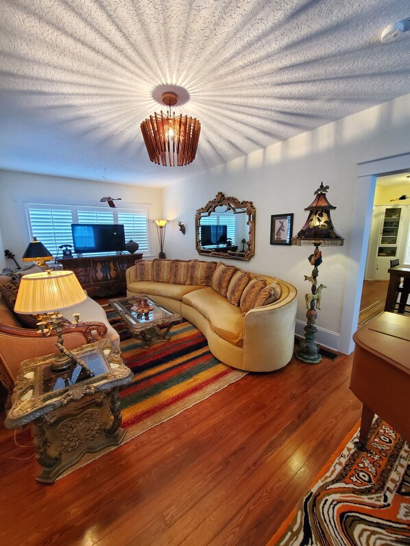 Relax in this stylish living room with a curved sofa, TV, and decorative touches.
