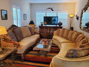 A living room with two sofas, a coffee table, a television, and decorative items.