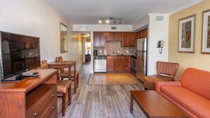 A compact living space with a kitchenette, a dining area, and a seating area with a sofa and a chair. - Coconut Cove All-suite (Clearwater Beach)