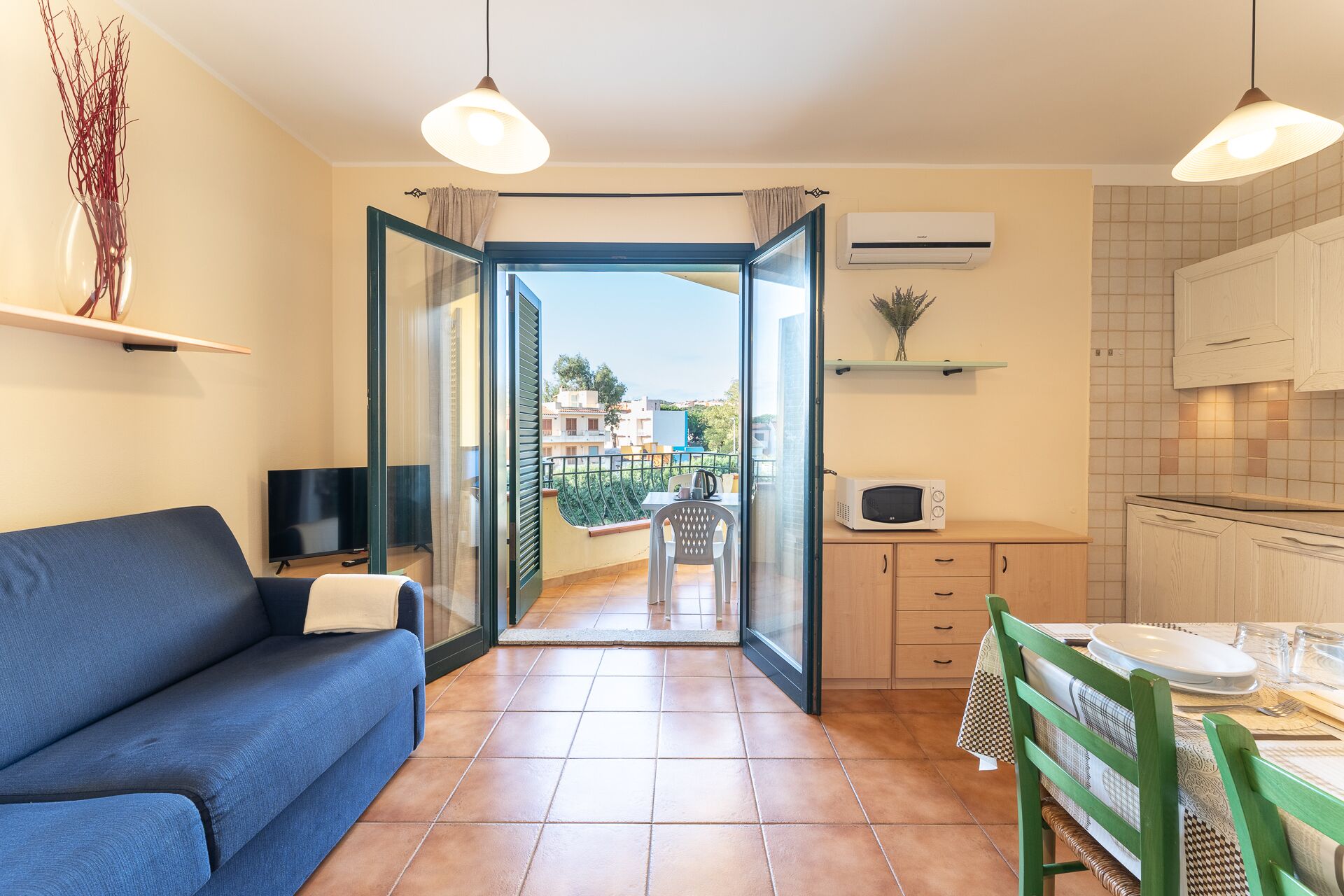 A modern apartment with a living room, kitchenette, and a balcony with a view.