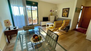 A modern living room with a glass dining table, yellow chairs, a sofa, a TV, and a painting on the wall. - Apartment/ flat - Coruña (O Pindo)