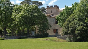 A stone building with a tower, surrounded by lush green trees and a well-maintained lawn. - Charming detached house for 2 with private jacuzzi. Prestige & design. (Carnas)