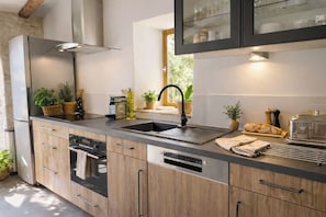 A modern kitchen with a built-in oven, a sink, and a toaster. - Charming detached house for 2 with private jacuzzi. Prestige & design. (Carnas)
