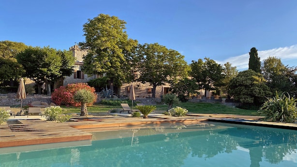 A swimming pool with a stone building in the background, surrounded by trees and greenery. - Charming detached house for 2 with private jacuzzi. Prestige & design. (Carnas)