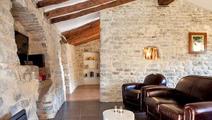 A rustic stone interior with exposed wooden beams, a leather sofa, and a fireplace. - Charming detached house for 2 with private jacuzzi. Prestige & design. (Carnas)