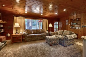 A cozy living room with a wooden ceiling, two sofas, a coffee table, and a bookshelf. - (52) Tuolumne Meadow at The Redwoods In Yosemite (Wawona)