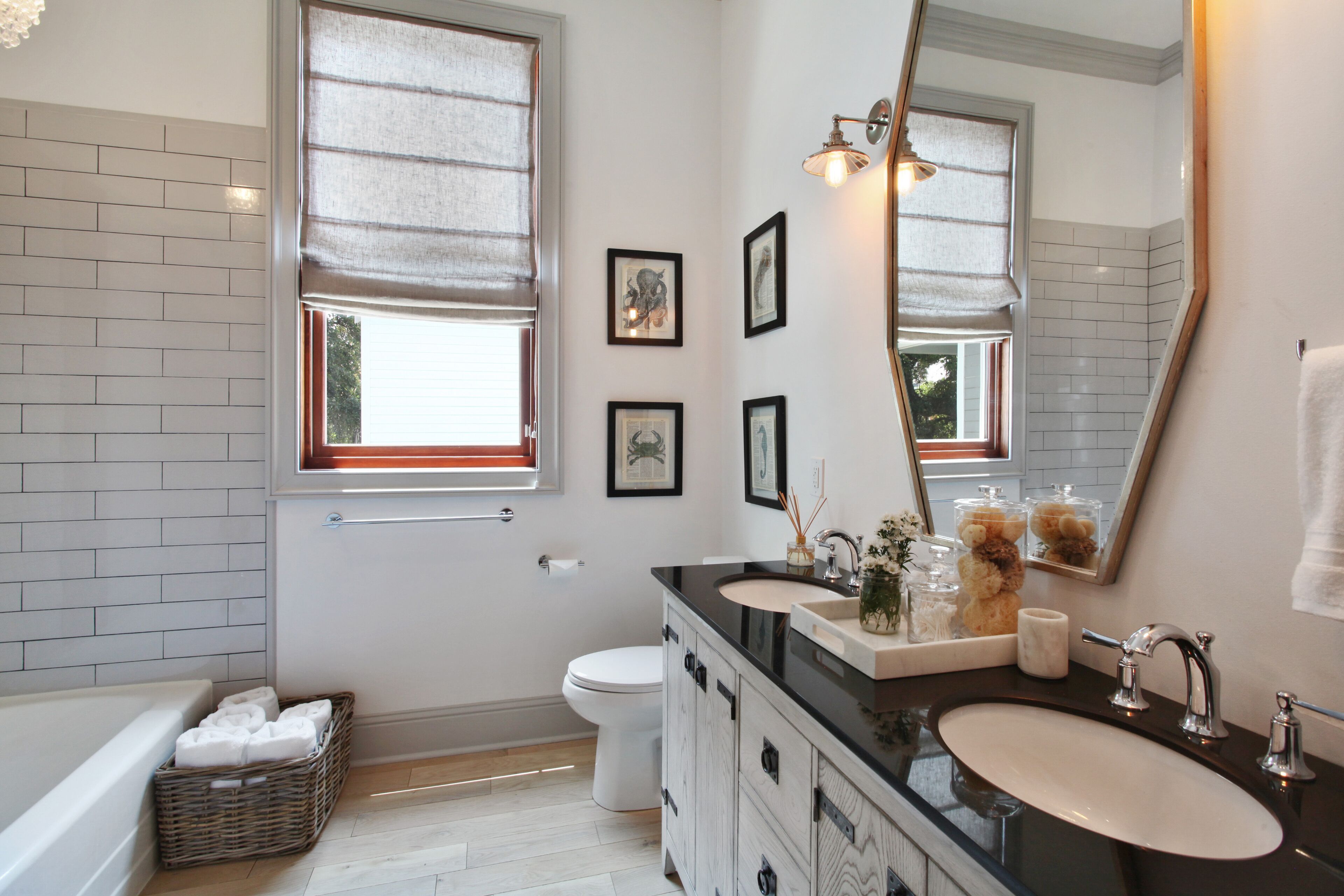 Une salle de bain moderne avec une baignoire, des toilettes, un meuble-lavabo et un grand miroir.