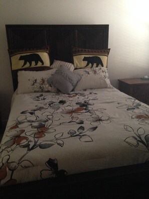 A bed with a floral bedspread and two pillows with bear designs. - River Access and just 3.5 miles from Downtown Franklin (Franklin)