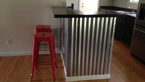 A kitchen with a stainless steel refrigerator, a white countertop, and a red stool. - River Access and just 3.5 miles from Downtown Franklin (Franklin)