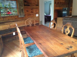 A wooden dining table with chairs, a television, and a window with a painting. - River Access and just 3.5 miles from Downtown Franklin (Franklin)