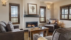 A cozy living room with leather sofas, a fireplace, and framed artwork on the wall. - Lone Cactus Ranch House Cottage Paradise Valley (Pray)