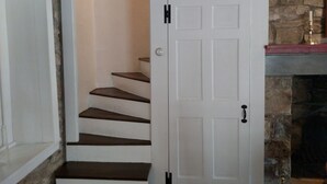 A staircase with a white door leading to a room. - New Hope area Historical Bucks County Stone House circa 1732 (Lumberville)
