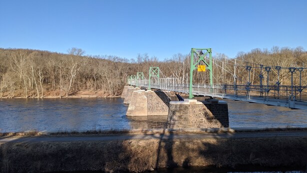 A bridge over a river with stone pillars and green metal railings. - New Hope area Historical Bucks County Stone House circa 1732 (Lumberville)