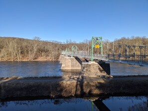 A bridge over a river with stone pillars and green metal railings.