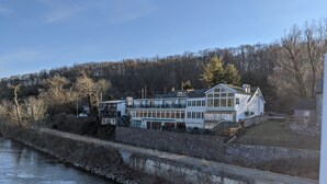 A waterfront hotel with multiple floors, a stone retaining wall, and a river beside it. - New Hope area Historical Bucks County Stone House circa 1732 (Lumberville)