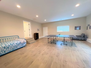 Relax in this spacious room featuring a table tennis table and comfortable seating areas.