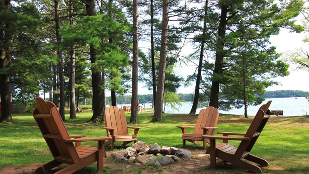 Two Adirondack chairs facing a lake with a dock labeled "Peavine View Dock" in the background.