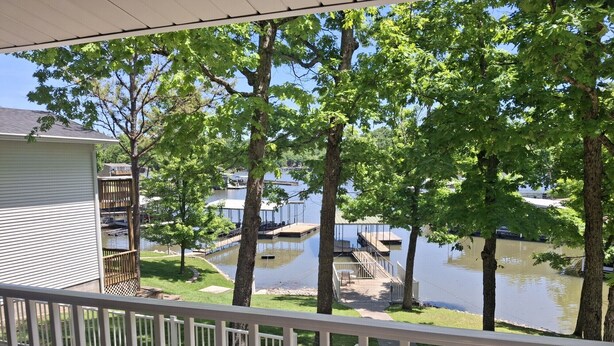 Une terrasse résidentielle offrant une vue sur un lac, un quai et des bateaux.